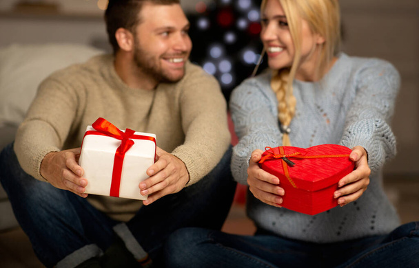Selective focus on Christmas gifts in couple hands - Photo, Image
