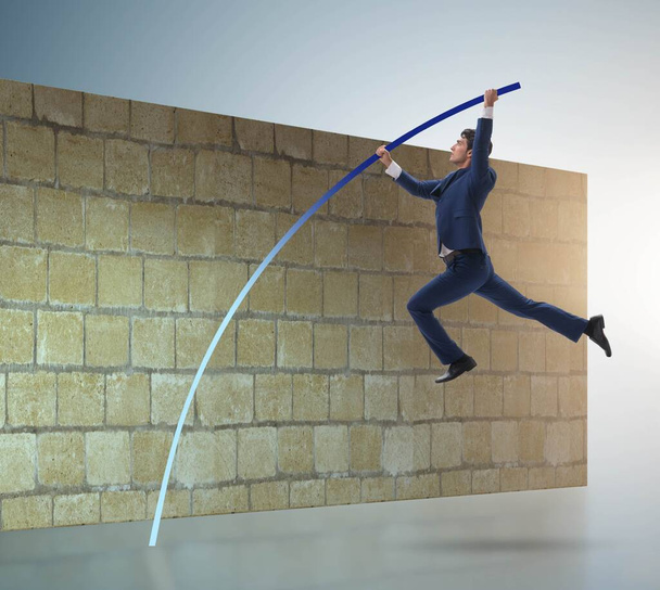 El hombre de negocios saltando sobre el muro de ladrillo en concepto de negocio - Foto, imagen