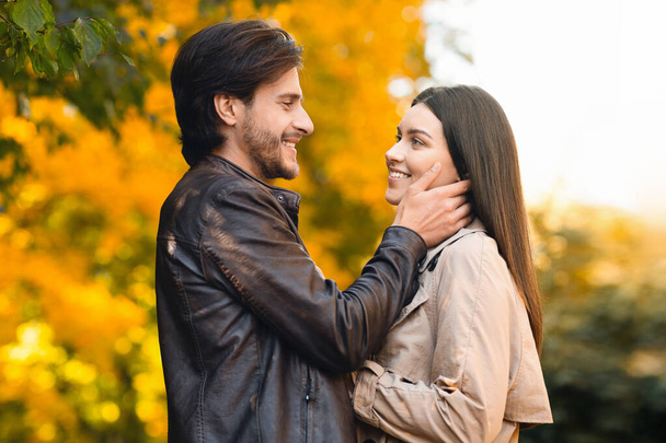 Hombre y mujer enamorados abrazándose en el bosque dorado - Foto, Imagen