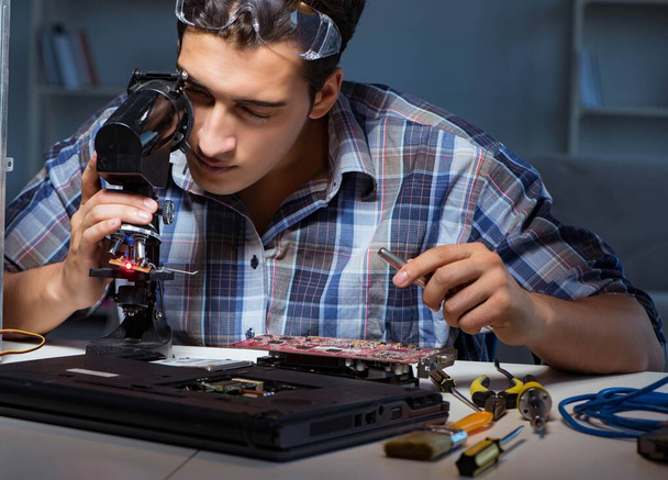 Reparador tentando reparar laptop com miscroscope - Foto, Imagem