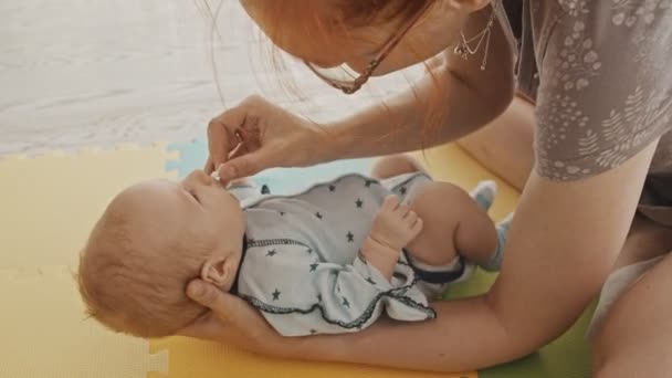 Mutter mit Baby - die Nase mit einem Wischtuch reinigen - Filmmaterial, Video