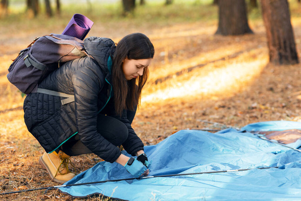 Młoda kobieta ustawia namiot w obozie, plecak na wsi - Zdjęcie, obraz