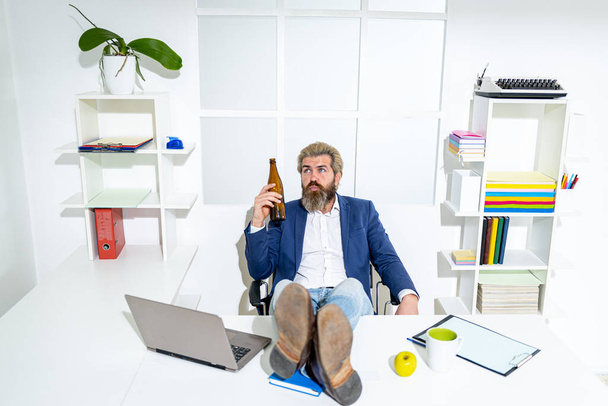Sad office worker desperate about unfair dismissal losing job. After hard work. Businessman hold a beer bottle. - Fotó, kép