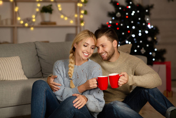 Šťastný manžel a manželka jásající s hrnky kakaa doma - Fotografie, Obrázek