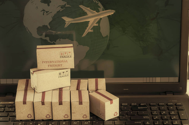 Cajas producto en teclado portátil. concepto de negocio de transporte, logística, envío global, carga internacional, comercio exterior, regional, ir a todo el mundo - Foto, imagen