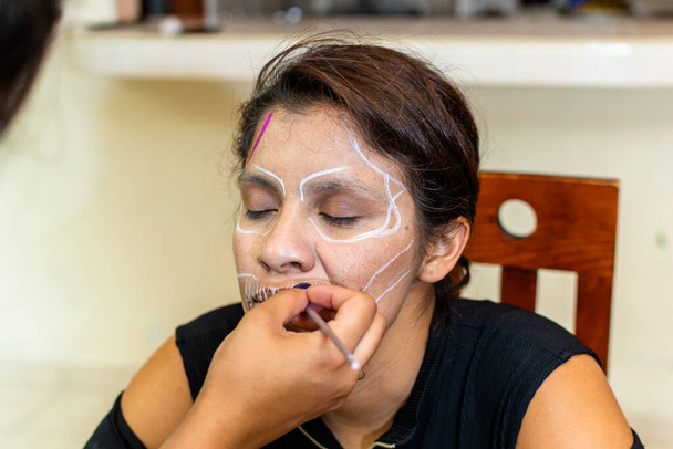mulher colocando maquiagem em outra mulher para uma festa do dia dos mortos - Foto, Imagem