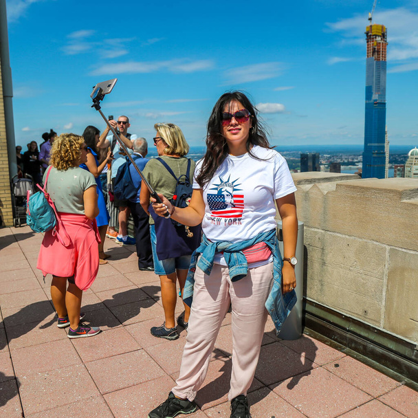 NEW YORK - SEPTEMBER 8, 2019: Tourists take selfie on the Top of the Rock Observation Deck at Rockefeller Center in New York - Foto, Bild