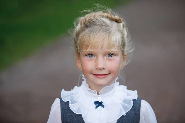 Portrait of a cute blonde girl in a school uniform. - Foto, Imagem