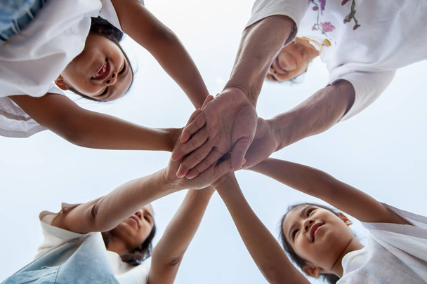 Азійська сім'я підтримує один одного. З "єднуйтесь руки, показуючи єдність і спільну працю.. - Фото, зображення