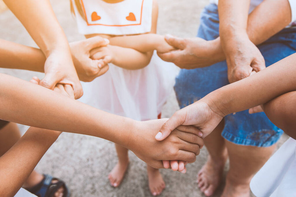 Die asiatische Familie hält Händchen. Familiengeneration legt Hand an und zeigt Einigkeit und Teamwork. - Foto, Bild