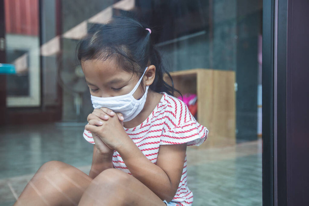 Asian child girl wearing protection mask praying for a new day freedom to coronavirus Covid-19 and stay at home quarantine from the coronavirus Covid-19 and air pollution pm2.5. - Photo, Image