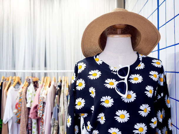 Schaufensterpuppen tragen Sommerkleid, florales Hemd, Sonnenbrille und Strohhut in der Nähe von Kleiderständern in der Garderobe mit Kopierraum. - Foto, Bild