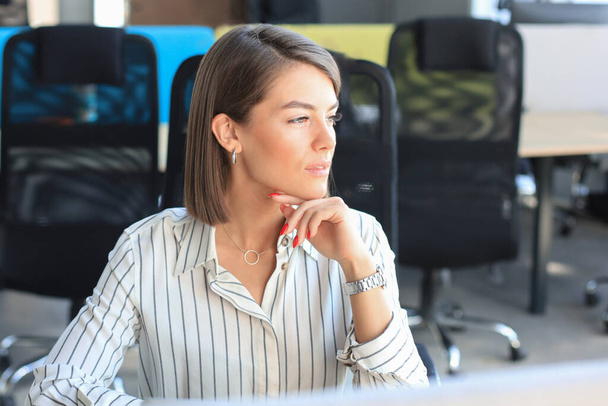 Sorrindo mulher moderna está pensando em negócios enquanto trabalhava no escritório - Foto, Imagem