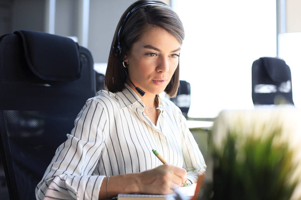 Female customer support operator with headset and smiling - Foto, Bild