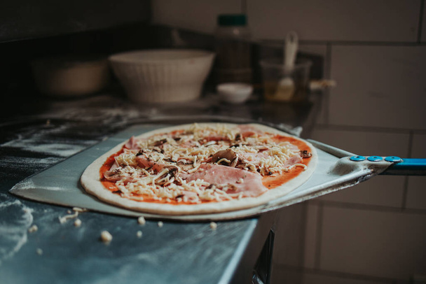 A closeup shot of a pizza getting prepared - Foto, Bild
