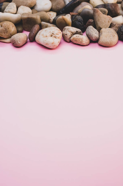 A vertical shot of rocks and pebbles on a pink surface - Photo, image