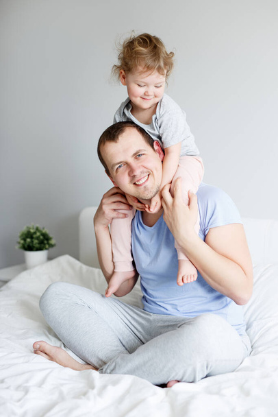 family, love, happiness and fatherhood concept - happy father having fun with his cute little daughter - Фото, изображение