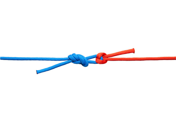 Two red and blue cords are connected . Knot on a cord isolated on a white background . - Zdjęcie, obraz