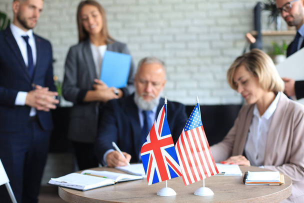 Two business partners signing a document. The United States of America and Great Britian - Zdjęcie, obraz