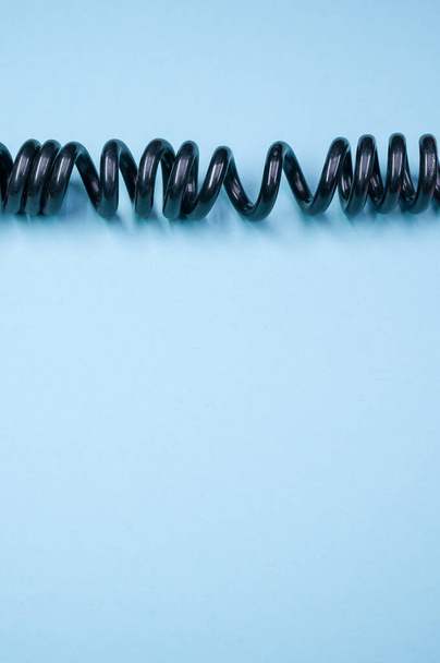 Függőleges felvétel egy elektromos kábelről egy kék felületen - Fotó, kép