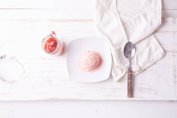 Вид зверху на рожеве морозиво на білій тарілці
 - Фото, зображення