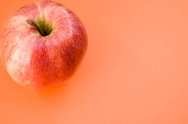 A top view of fresh red apple isolated on an orange background - Foto, imagen