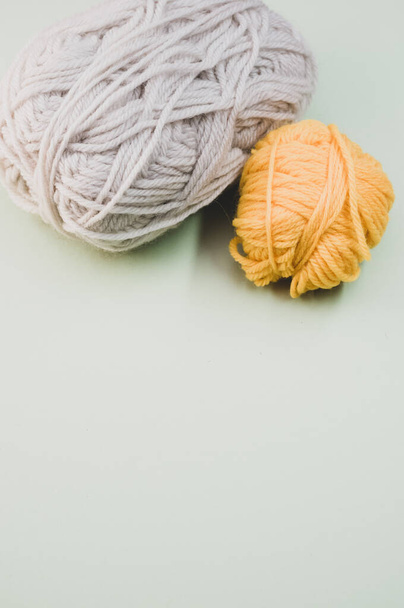 A vertical shot of two balls of yarn on a grey surface - Fotoğraf, Görsel