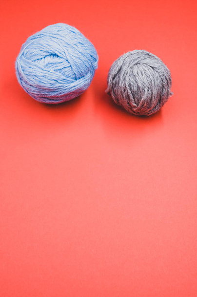 A vertical shot of two balls of yarn on a red surface - Foto, immagini