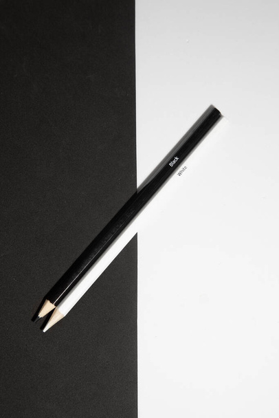 A vertical shot of two black and white wooden pencils on a black and white background - Zdjęcie, obraz