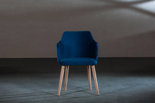 A blue dining room chair in a studio with gray walls - Fotoğraf, Görsel