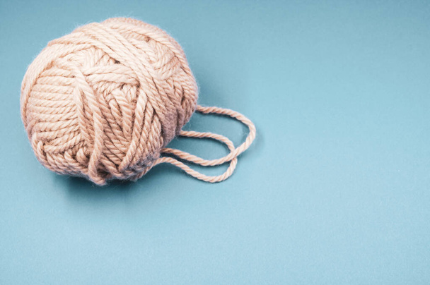A high angle shot of a ball of yarn on a blue surface - 写真・画像