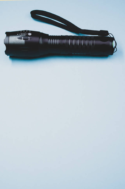 A black torch on a light blue background - 写真・画像