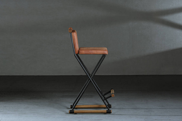 Μια απλή ξύλινη καρέκλα κουρέα σε ένα στούντιο κάτω από τα φώτα - Φωτογραφία, εικόνα