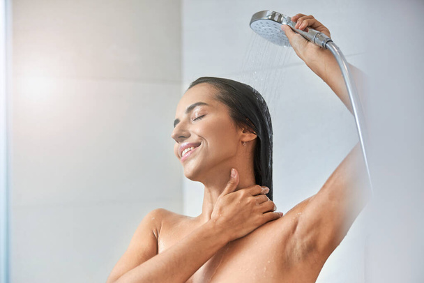 vreugdevolle jonge vrouw nemen douche thuis - Foto, afbeelding