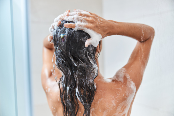 Junge Frau wäscht sich unter der Dusche die Haare - Foto, Bild