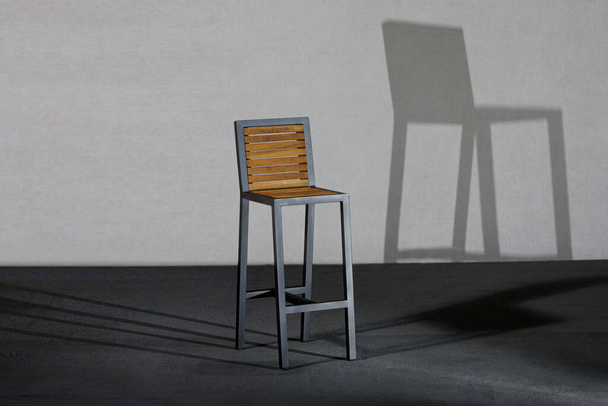 A closeup of a high loft-style chair, the shadow of the chair on the back wall - Foto, Bild