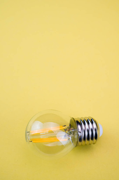 A top view of the  light bulb on the yellow  surface - Foto, Imagen