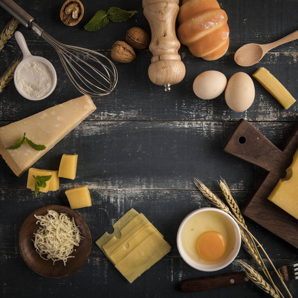 A top view of a delicious cheese platter with walnuts, eggs, and flour on a table with copy space - Foto, Imagen