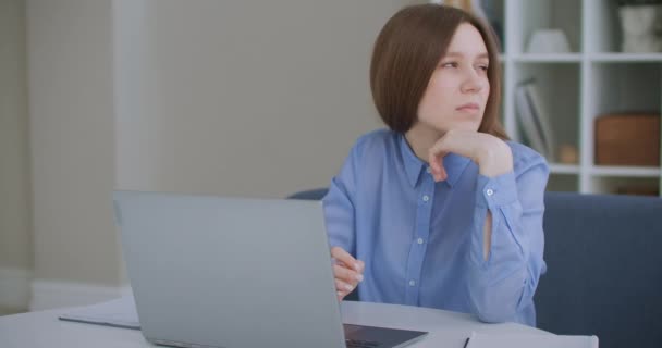 Zamyšlená seriózní mladá žena student spisovatel sedět doma kancelář stolu s notebookem myšlení inspirace hledání řešení problému myšlenky ztracené v myšlenkách koncept snění dívá pryč - Záběry, video