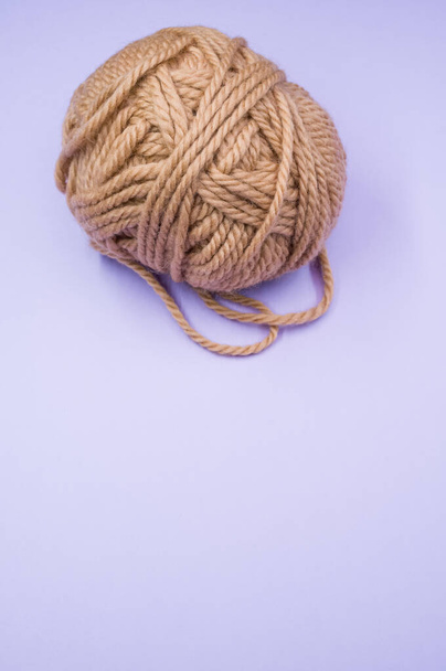 A vertical shot of a ball of yarn on a blue surface - Valokuva, kuva