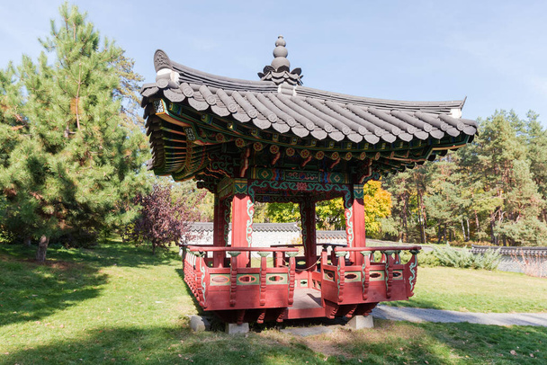 Ξύλινο κιόσκι με τη μορφή παραδοσιακής παγόδας στον κορεάτικο κήπο στο πάρκο του φθινοπώρου - Φωτογραφία, εικόνα