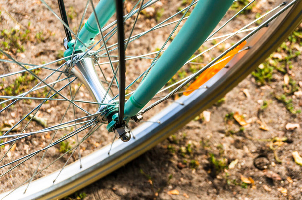 A closeup of a bicycle tire on the ground under the sunlight with a blurry background - Fotó, kép