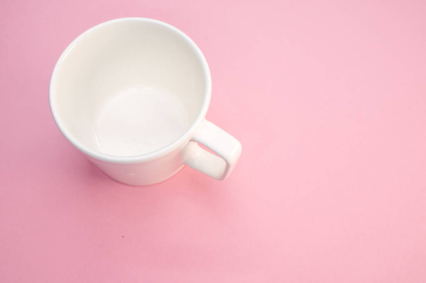 A high angle shot of an empty cup on a pink surface - Foto, afbeelding