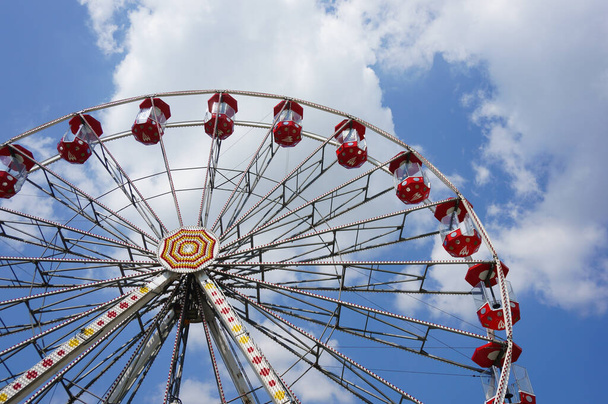 High Ferris wheel with red seats at a fun park - Foto, imagen