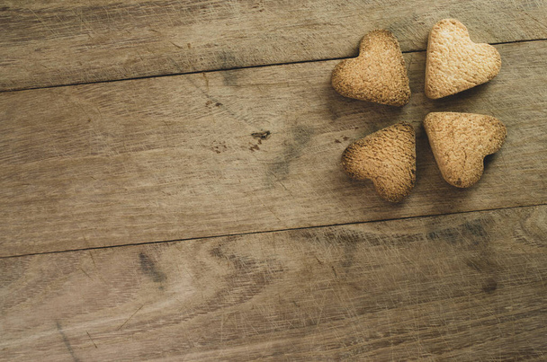 A top view shot of heart-shaped cookies on a wooden surface - concept of love - Φωτογραφία, εικόνα