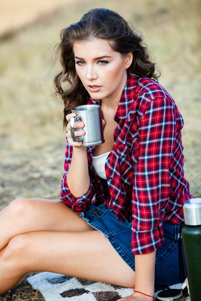 Beautiful girl drinks tea outdoors.  Hipster woman relaxing in nature. - Photo, Image