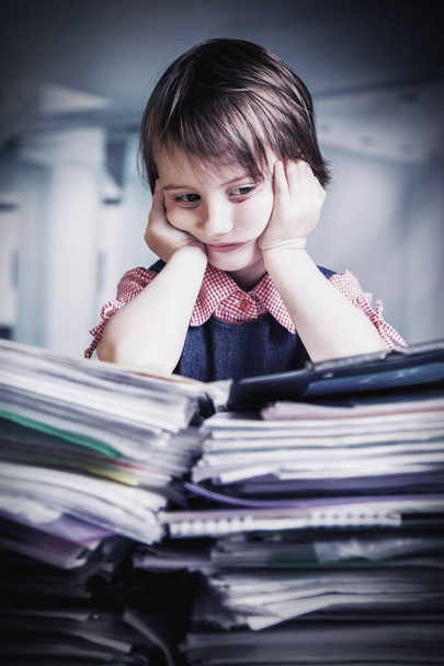 Psychosomatics and problems with physical and psychological health at office work. Tired and exhausted  business child girl working alone with lot of documents.  Humorous portrait. - Photo, Image