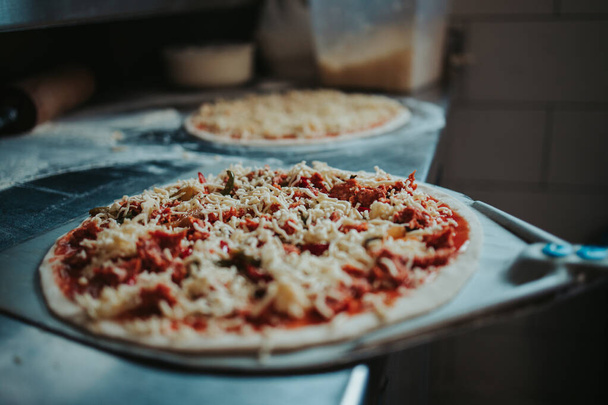 A closeup shot of a pizza getting prepared - Photo, Image