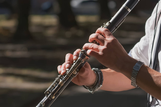 Close up musician  playing clarinet on a city sidewalk.  - Photo, Image