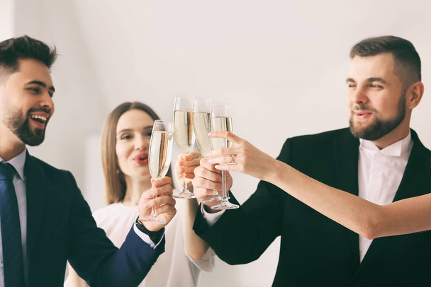 Молоді люди смердять келихи смачного шампанського на вечірці в офісі
 - Фото, зображення